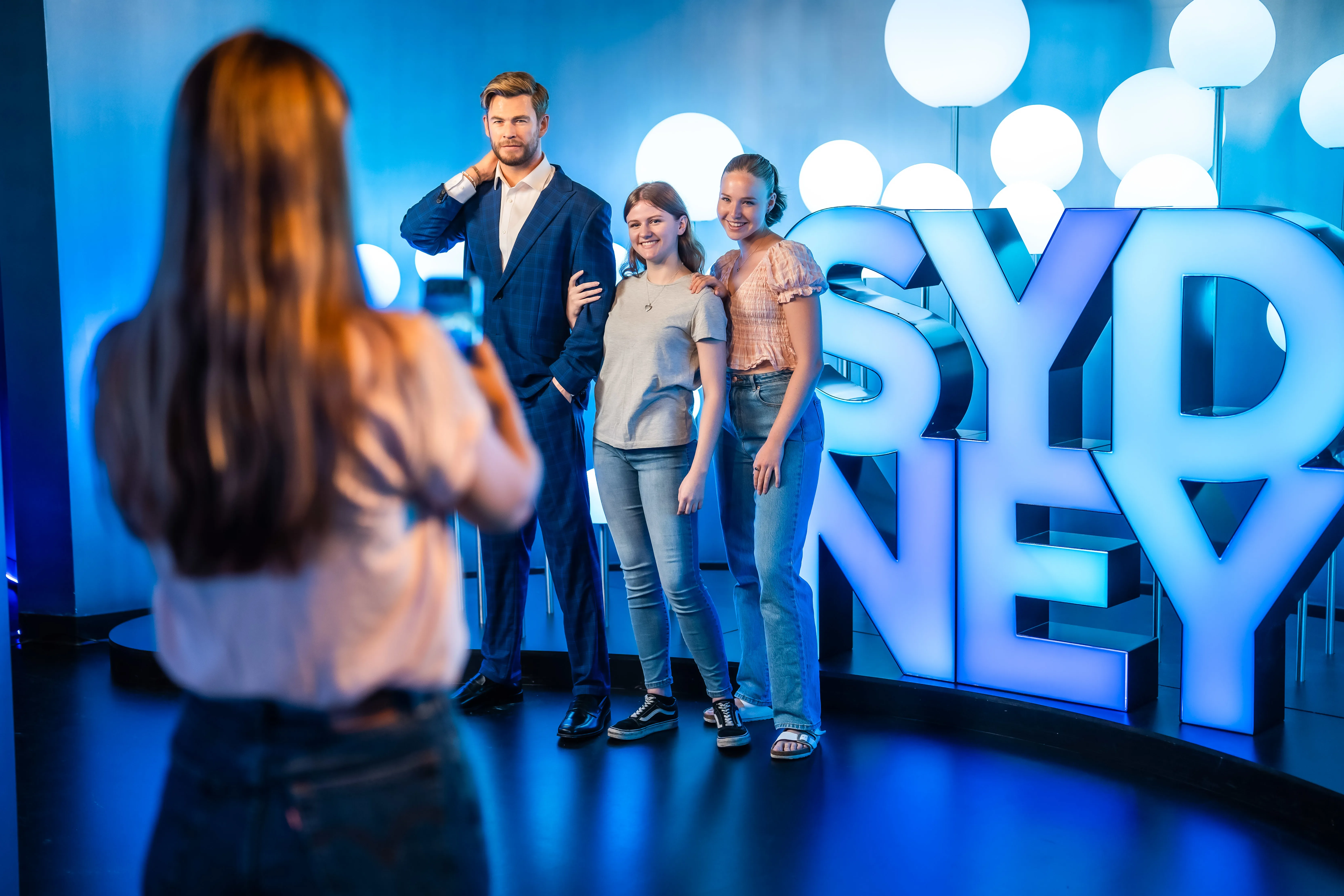 Guests posing with Chris Hemsworth Wax Figure and SYDNEY Sign