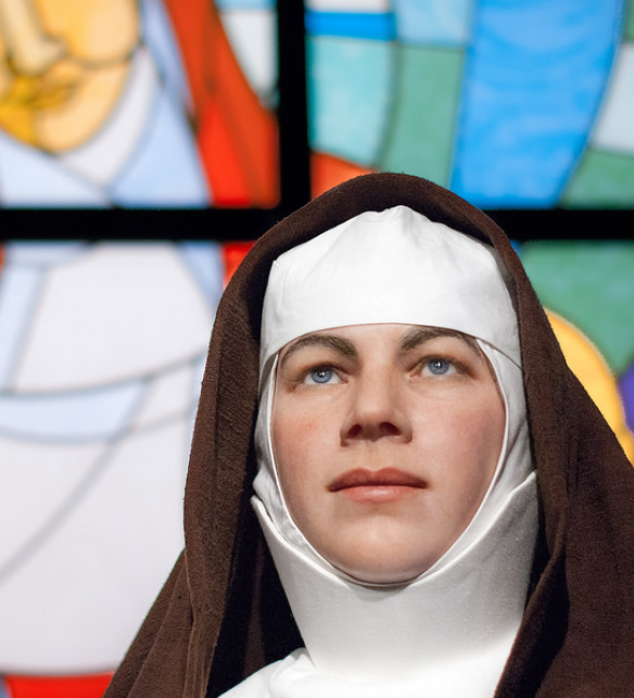 mary mackillop wax work in front of stain glass window