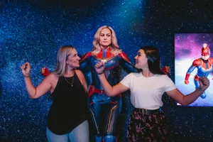 Guests posing with Captain Marvel at Madame Tussauds