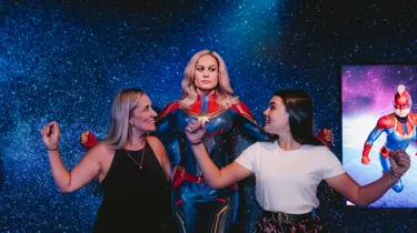 Guests posing with Captain Marvel at Madame Tussauds