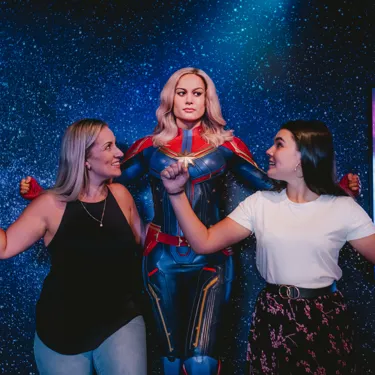 Guests posing with Captain Marvel at Madame Tussauds