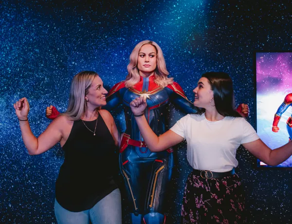 Guests posing with Captain Marvel at Madame Tussauds
