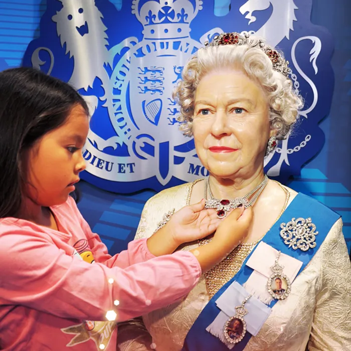Mädchen bewundert die Juwelen von Queen Elizabeth II im Madame Tussauds™ Wien